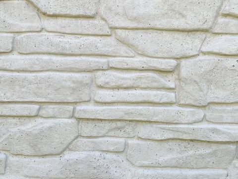 Textured white stone wall featuring a natural pattern that provides a rustic Stock Photos