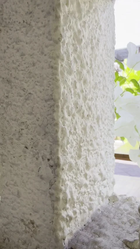 Textured White Wall with Small Window Framing Flowers and Sky Stock Footage 332542637