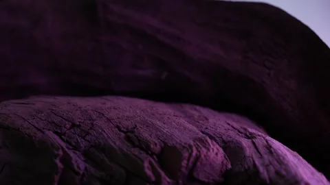 Textured wood surface lit with dramatic purple lighting in dark scene Stock Footage 312517164