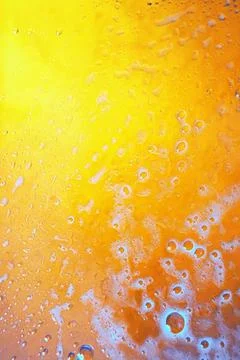 Textured yellow-orange background of drops and bubbles Stock Photos