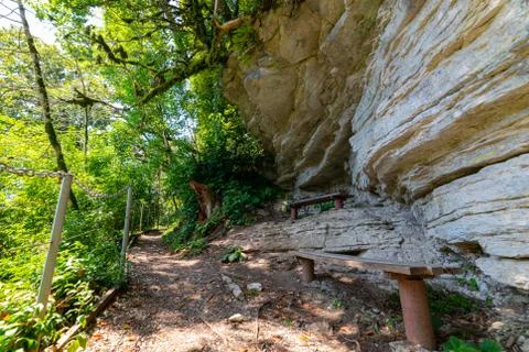 Textures of various stone layers on cliff. Benches in rest place on hiking tr Stock Photos