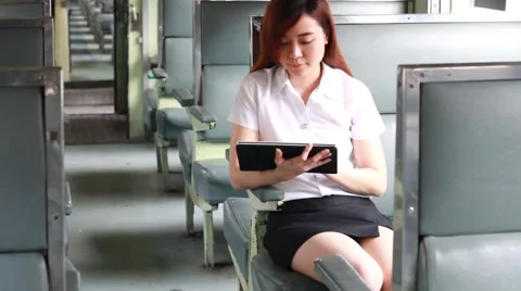 Thai adult beautiful girl using her tablet, Leisure travel by rail Stock Footage 59594800