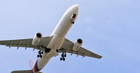 Thai Airways airplane departs from airport and flies above camera into blue sky Stock Footage