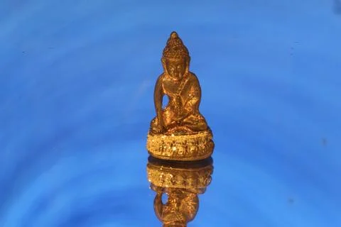 Thai amulet or votive tablet made of metal or clay isolated on blue backgro.. Stock Photos