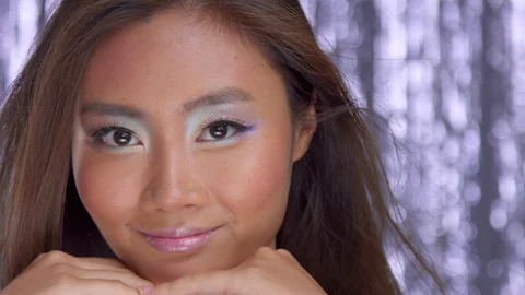 Thai asian model in studio with silver rain disco background and party makeup Stock Footage 101163610