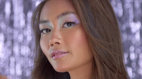 Thai asian model in studio with silver rain disco background and party makeup Stock Footage 101166690