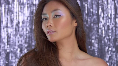 Thai asian model in studio with silver rain disco background and party makeup Video stock 101173962