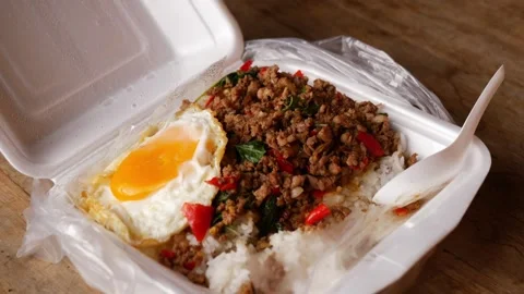 Thai basil stir-fried minced pork with crispy fried egg over steamed rice in a Stock Footage 348336679