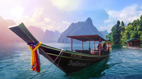 Thai boat in sea with mountains in background Stock Photos
