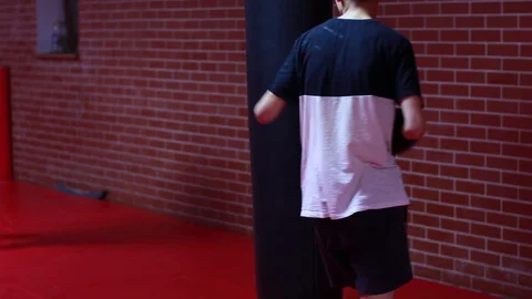 Thai Boxing Training. The guy hits a punching bag. Gym. 動画素材 118884209