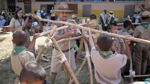 Thai Boy Scout students in uniform making wooden catapult teacher join sticks Stock Footage 157281376