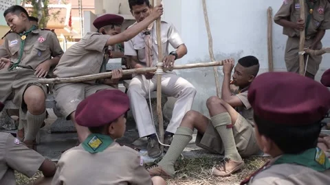 Thai Boy Scout students in uniform making wooden catapult teacher join sticks Stock Footage 157442551