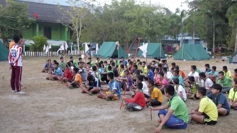 Thai Boy Scout teacher talk to students on meeting sitting on the grass Stock Footage 157441259