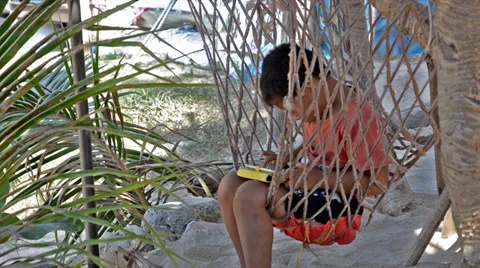 Thai child on hammock using tablet Видео 36022334