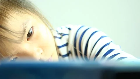 Thai child is lying on desk as play smartphone at home, in  studio   Chiangmai   Stock Footage 164010984