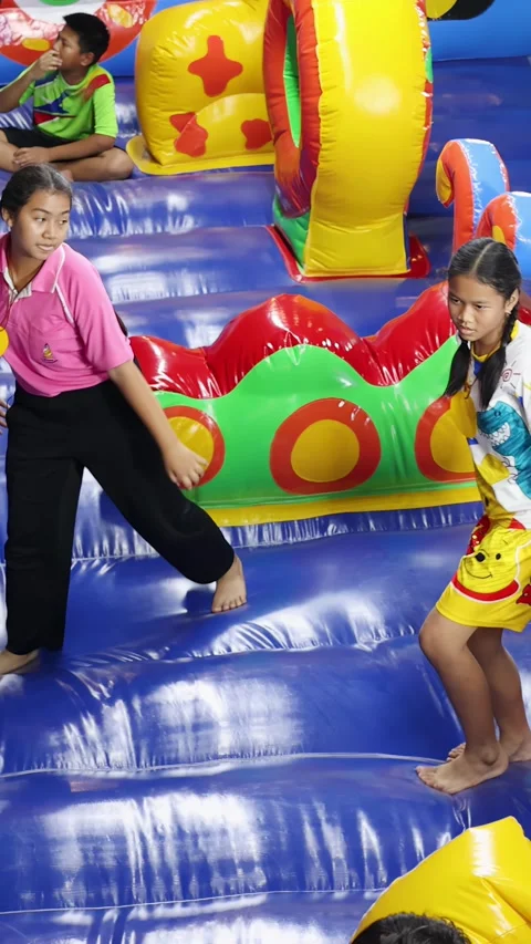 Thai Children Playing and Jumping on Colorful Inflatable Bounce House Stock Footage 328080036