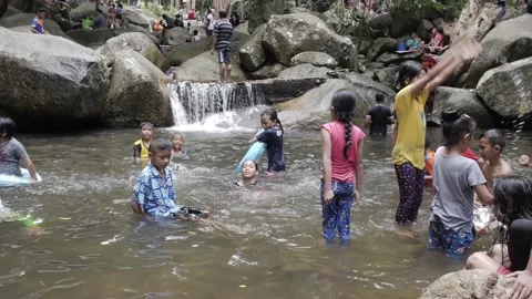 Thai children playing in waterfall pool big rocks happy kids enjoying swim Stock Footage 157446897