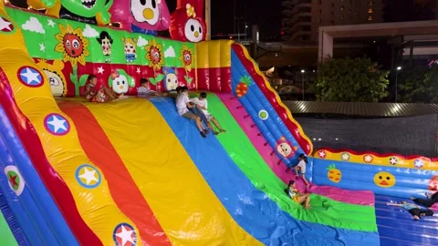 Thai Children Sliding Down Large Inflatable Slide at Night Carnival Stock Footage 327629266