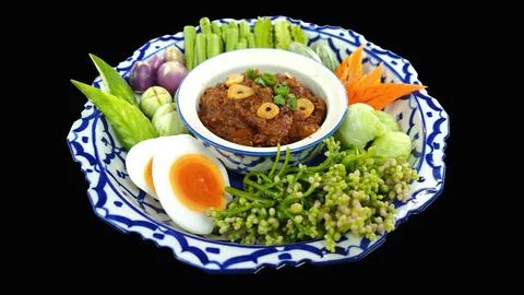Thai chili paste dip with boiled egg and fresh vegetables on black  background. Foto stock