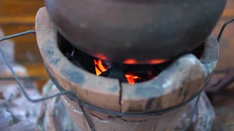 Thai clay pot hot pot cooking on charcoal stove with burning fire Stock Footage 320768925