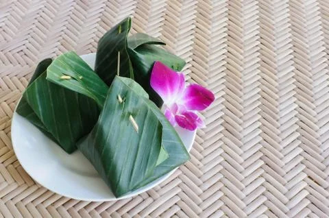 Thai dessert wrapped in banana leaves Stock Photos