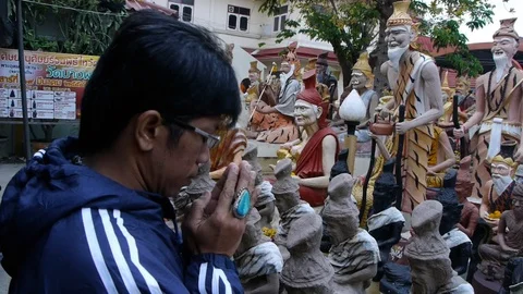 A Thai devotee prays at an altar dedicated to the forest hermit. Video stock 123472280