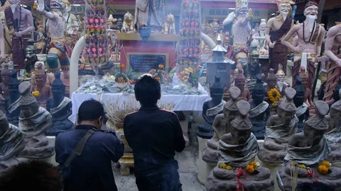 Thai devotees pray at an altar dedicated to the forest hermit. Video stock 123472325