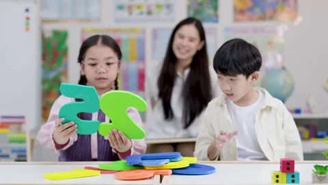 Thai Elementary Students Learning Math with Foam Numbers in Classroom Vídeos de archivo 334172183