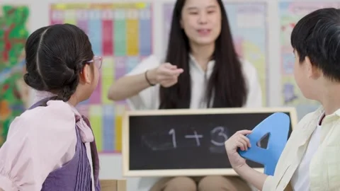Thai Elementary Students Solve Math Problems with Teacher in Classroom Vídeos de archivo 334992002