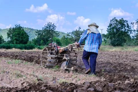 Thai farmer using walking tractors for cultivated soil for prepare plantation Stock Photos