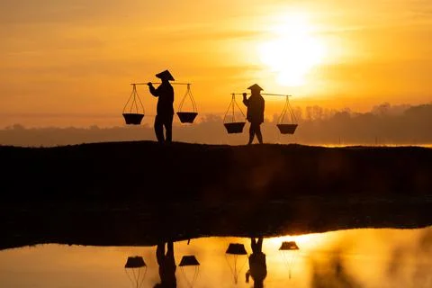 Thai farmers are carrying baskets to prepare to go home before the sun goes d Stock Photos