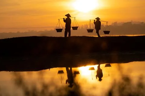 Thai farmers are carrying baskets to prepare to go home before the sun goes d Stock Photos