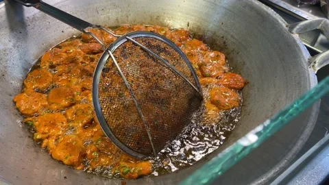 Thai fish pancakes being deep fried in oil in the Thai street food market. Stock Footage 205546639