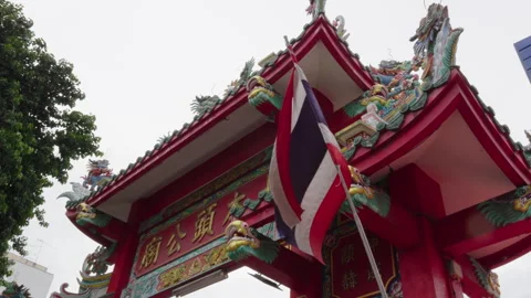 Thai flag flying over an ornate temple gate Stock Footage 345860142
