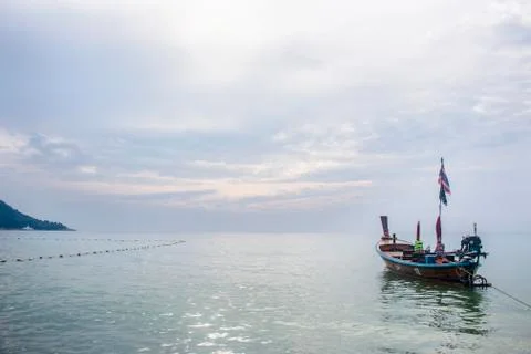 Thai flag slightly flapping in a long-tail boat docked in Kata beach, during a Foto stock