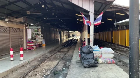 Thai flags on wooden pole with empty train track at Mahachai railway station Stock Footage 196268223