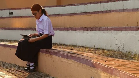 Thai girl student using tablet and siting at the park Stock Footage 75158125