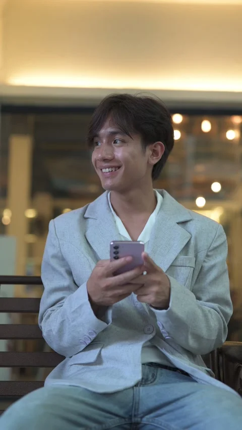 Thai Isan professional or student smiling while typing on a pink smartphone Stock Footage 338036056