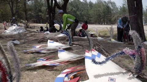 Thai kite festival kiter checking his traditional paper fight Wau kites Stock Footage 157447830