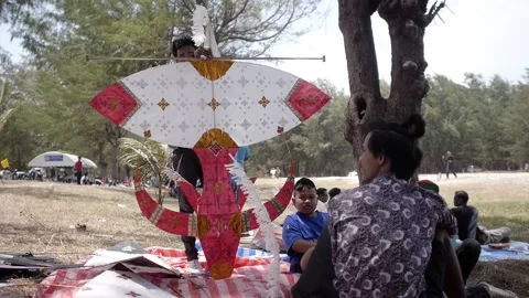 Thai kite festival kiter checking his traditional hand made paper Wau Bulan Kite Stock Footage 157447955