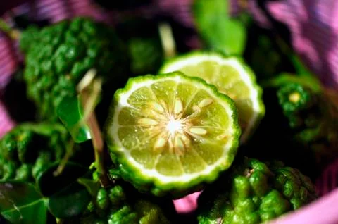 Thai limes with wrinkled skin, whole and halved Stock Photos