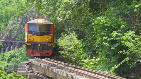 Thai local old classic train on railway on River Kwai Bridge in Kanchanaburi  Stock Footage 136711908