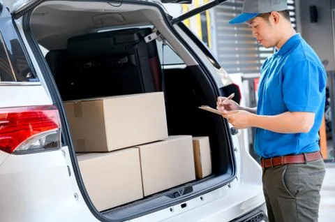 Thai mailman checking parcel and mail boxes for home delivery. Stock Photos