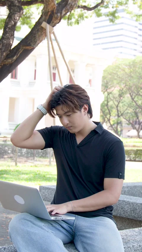Thai Male Student Using Laptop Outdoors on University Campus Park Bench Stock Footage 334762831