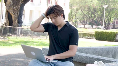 Thai Male Student Using Laptop Outdoors on University Campus Park Bench Stock Footage 335626569