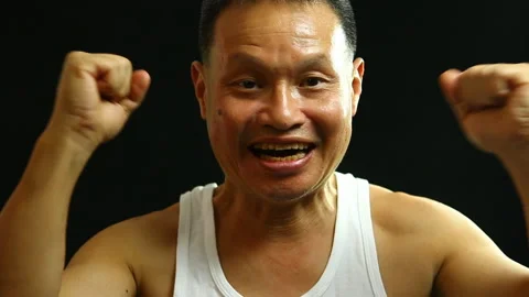 Thai man cheering  with black background, in studio   Chiangmai Thailand Stock Footage 147378991