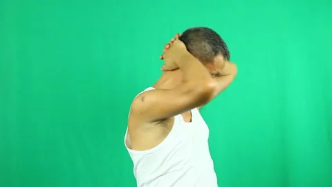 Thai man exercise his neck with green background, in studio   Chiangmai Thailand Stock Footage 147379386