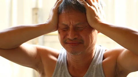 Thai man is  holding head by hands, in  door  Chiangmai  Thailand. Stock Footage 221167616