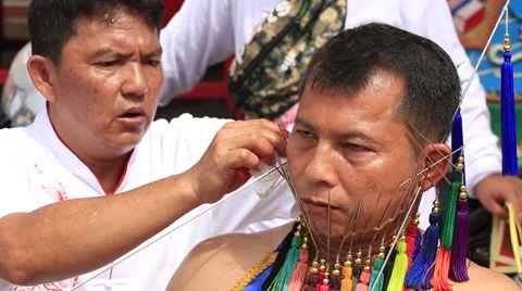 Thai man with needles in his face on the vegetarian festival. Phuket, Thailand Stock Footage 56517654