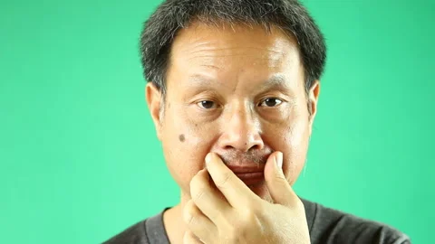 Thai man is touching his moustache with green background , in studio Chiangmai T Stock Footage 233770922